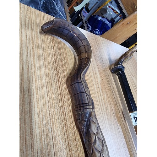 264 - 2 walking sticks, a carved cobra walking stick (has an old repair to the top) the other stick has an... 