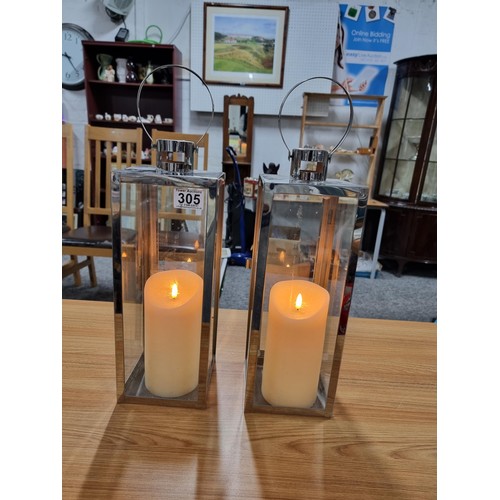 305 - 2 x Lantern lamps both stainless steel construction and both with battery operated pillar candles bo... 