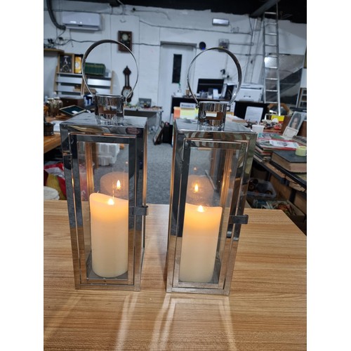 305 - 2 x Lantern lamps both stainless steel construction and both with battery operated pillar candles bo... 