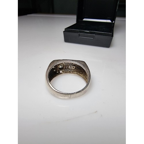 334 - A small gents 925 silver ring inset with sparkly CZ crystal stones. In clean condition and boxed. Si... 