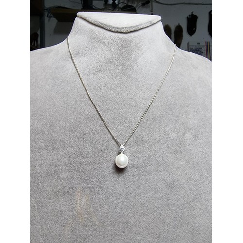 340 - A 925 silver faux pearl pendant with a CZ crystal stone set on an 18