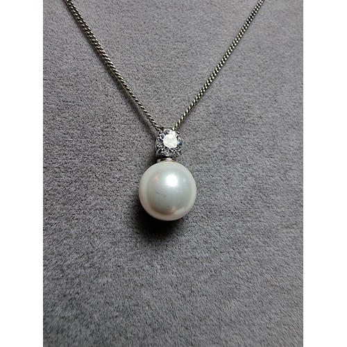 340 - A 925 silver faux pearl pendant with a CZ crystal stone set on an 18