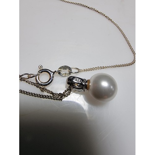 340 - A 925 silver faux pearl pendant with a CZ crystal stone set on an 18