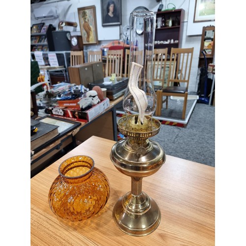 313 - A brass oil lamp with an ornate amber glass shade, in good clean condition, complete with a new wick... 