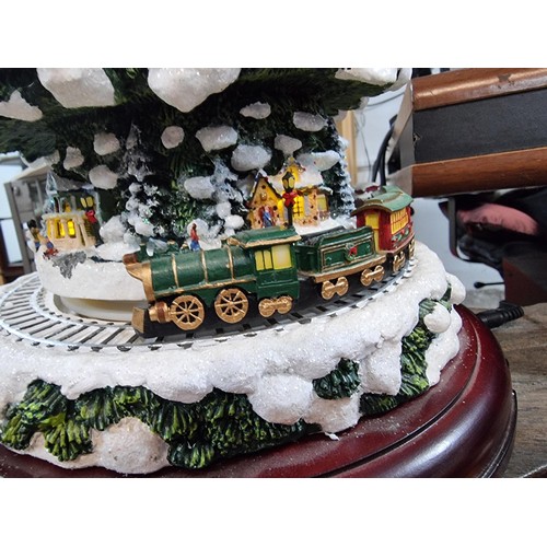 321 - A Thomas Kinkade wonderland express Christmas feature which includes moving trains which go around t... 