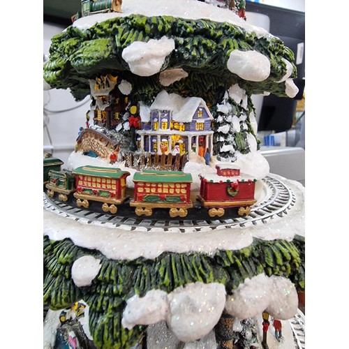 321 - A Thomas Kinkade wonderland express Christmas feature which includes moving trains which go around t... 