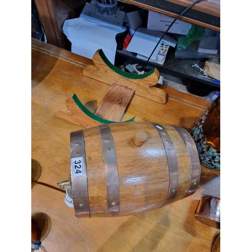 324 - A heavy solid oak copper bound barrel keg on stand along with a brass spigot and a small ceramic buc... 