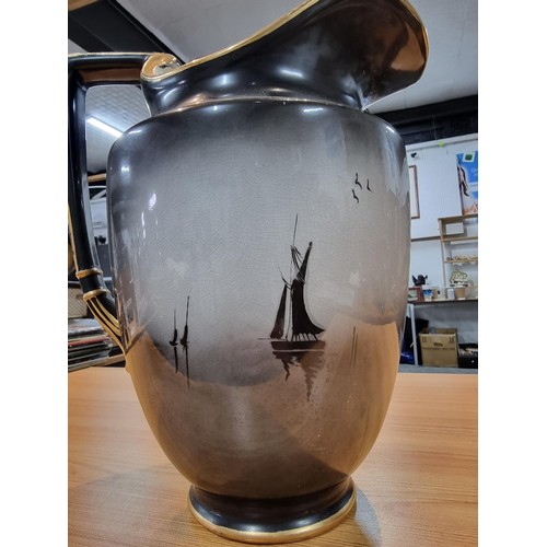 326 - A large impressive black ceramic decorative urn jug with an ornate gilt design of a Japanese boat an... 