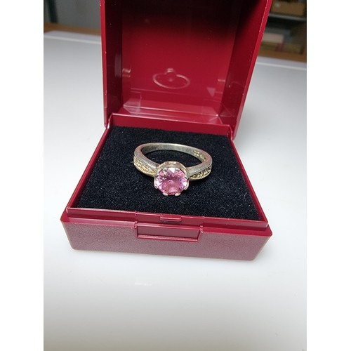 332 - An ornate 925 silver dress ring inset with a large pink crystal CZ stone and smaller clear CZ stones... 