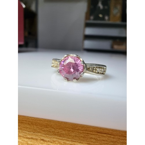 332 - An ornate 925 silver dress ring inset with a large pink crystal CZ stone and smaller clear CZ stones... 