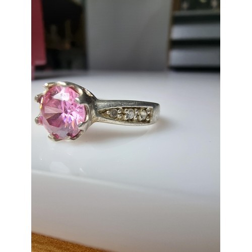 332 - An ornate 925 silver dress ring inset with a large pink crystal CZ stone and smaller clear CZ stones... 