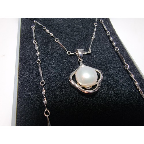 333 - A 925 silver pendant inset with a real pearl, set on a 16