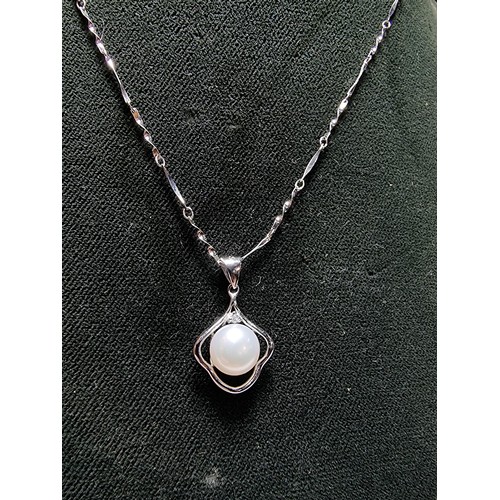 333 - A 925 silver pendant inset with a real pearl, set on a 16