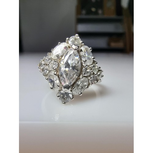 338 - An ornate as new 925 silver cluster dress ring inset with a large quantity of sparkly crystal CZ sto... 