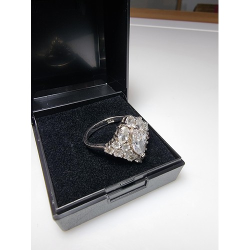 338 - An ornate as new 925 silver cluster dress ring inset with a large quantity of sparkly crystal CZ sto... 