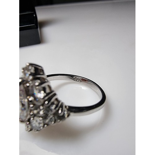 338 - An ornate as new 925 silver cluster dress ring inset with a large quantity of sparkly crystal CZ sto... 