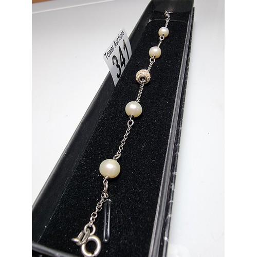 341 - A 925 silver bracelet inset with real pearls and a jewelled charm, total length of 8.5