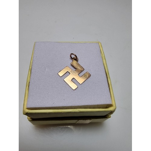 394 - A 9ct yellow gold Swastika pendant/charm, believed to have been found after a Nazi march. Weight of ... 