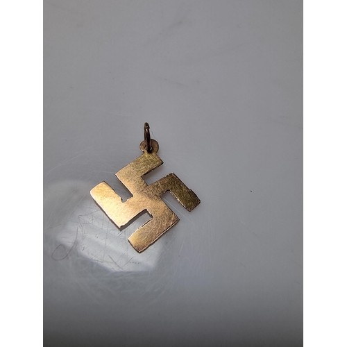 394 - A 9ct yellow gold Swastika pendant/charm, believed to have been found after a Nazi march. Weight of ... 