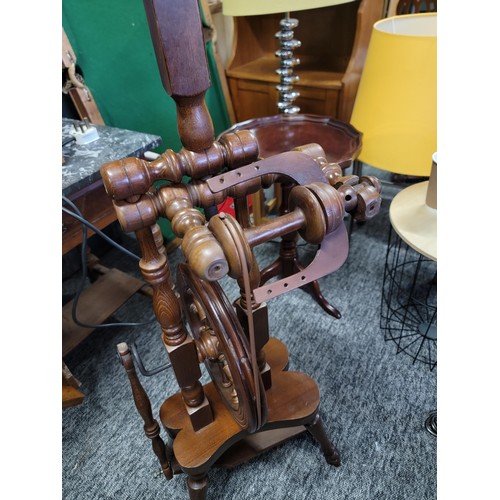 213 - A solid wood spinning wheel, complete with cord and pedal in good condition. Stands at 128cm high , ... 