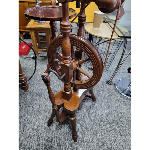 213 - A solid wood spinning wheel, complete with cord and pedal in good condition. Stands at 128cm high , ... 