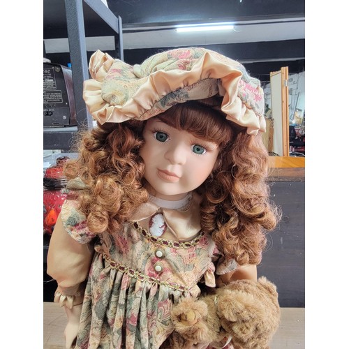 190 - Soft expression hand painted porcelain doll in floral dress holding a teddy bear from the series of ... 