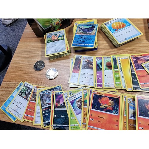 50 - A large quantity of approx 300 Pokémon cards fitted in a metal Pokémon tin along with 4 other empty ... 