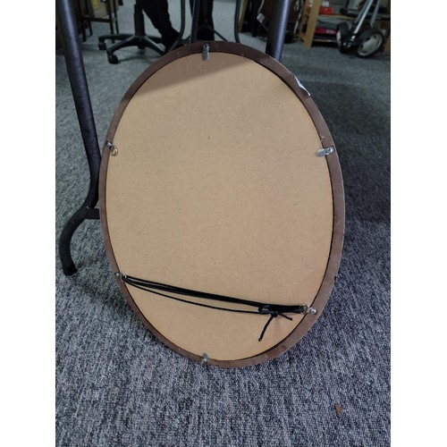 63 - Oval black framed mirror in good order height 55cm width 44cm