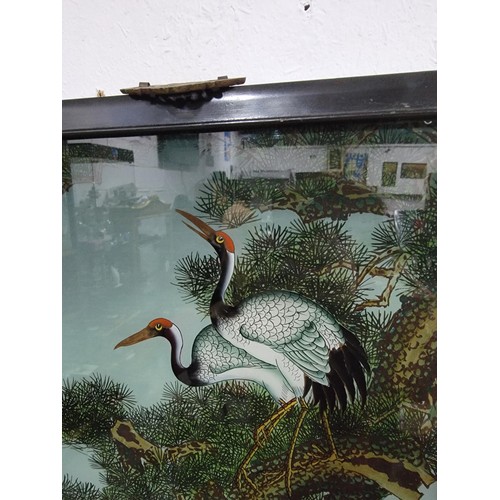 109 - A framed and glazed antique painting of 2 cranes in a tree, signed to the top left along with a doub... 