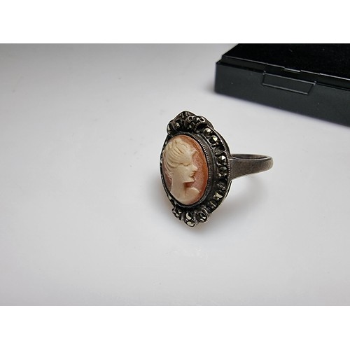 153 - A vintage sterling silver cameo ring carved out of shell surrounded by marcasite stones of a lady lo... 