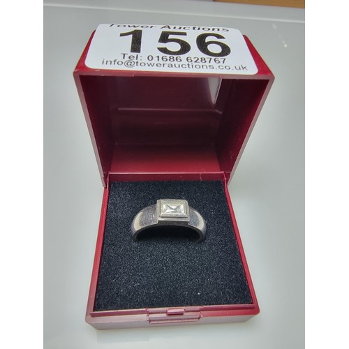 156 - A chunky 925 silver ring inset with a baguette cut CZ crystal stone. In clean condition, boxed, size... 