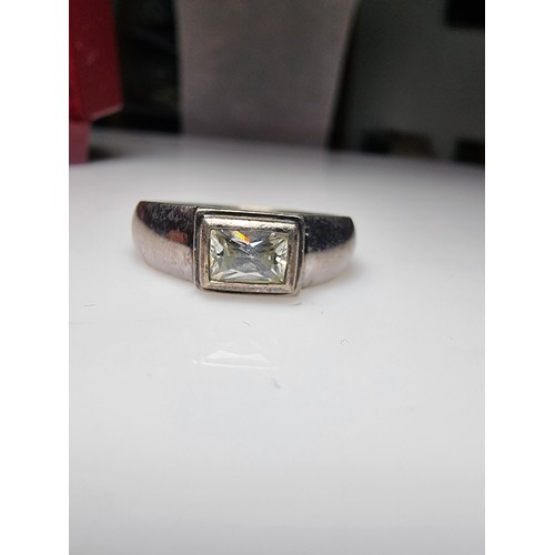 156 - A chunky 925 silver ring inset with a baguette cut CZ crystal stone. In clean condition, boxed, size... 