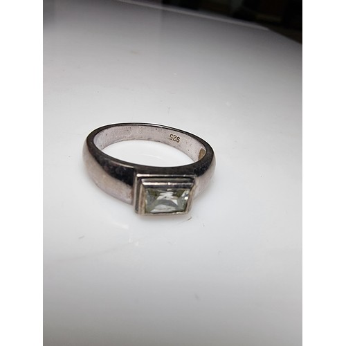 156 - A chunky 925 silver ring inset with a baguette cut CZ crystal stone. In clean condition, boxed, size... 