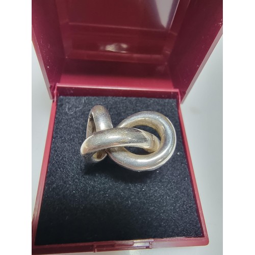 157 - An unusual chunky 925 silver ring with a fluent knot design, in good clean condition, boxed, size P,... 