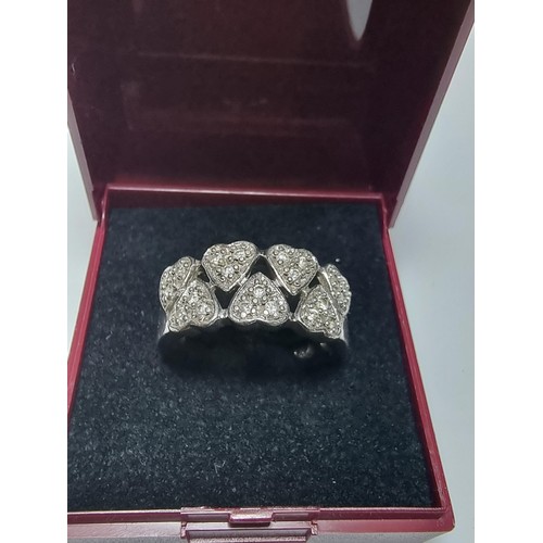 180 - A chunky 925 silver ring with a heart design inset with crystal CZ stones. In clean condition, boxed... 