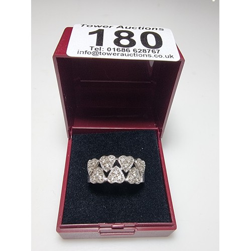 180 - A chunky 925 silver ring with a heart design inset with crystal CZ stones. In clean condition, boxed... 