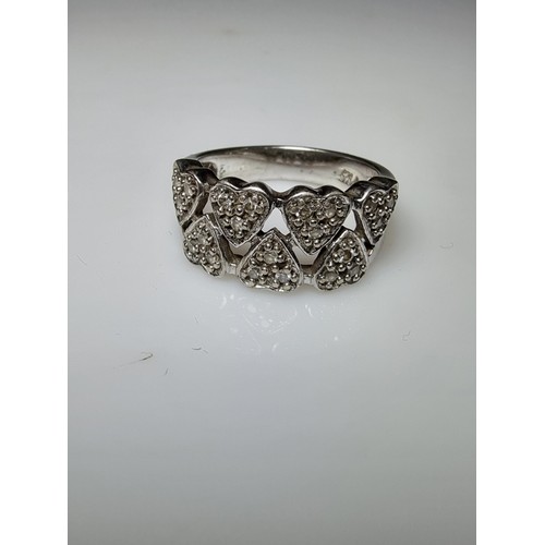 180 - A chunky 925 silver ring with a heart design inset with crystal CZ stones. In clean condition, boxed... 