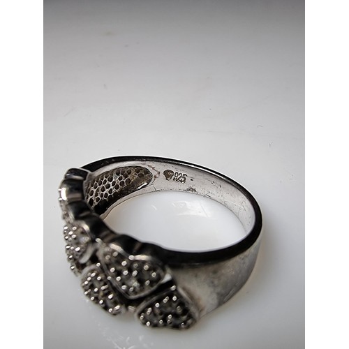 180 - A chunky 925 silver ring with a heart design inset with crystal CZ stones. In clean condition, boxed... 