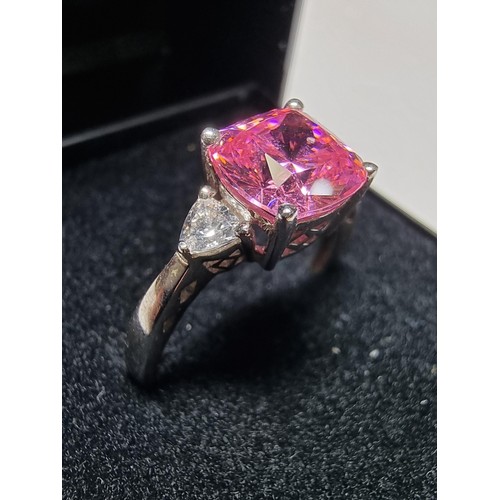 181 - A very pretty 925 silver dress ring inset with a large cushion cut pink crystal CZ stone with 2 clea... 