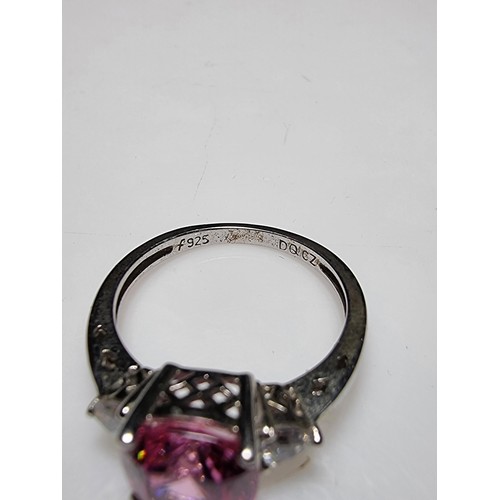 181 - A very pretty 925 silver dress ring inset with a large cushion cut pink crystal CZ stone with 2 clea... 