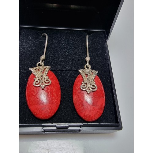 182 - A pair of pretty 925 silver and red stained wood earrings with an ornate design. In good clean condi... 