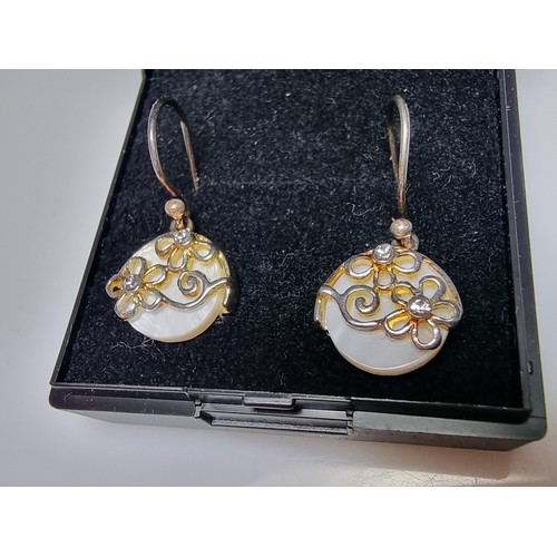 183 - A pair of pretty 925 silver drop earrings inset with mother of pearl having a floral design inset wi... 