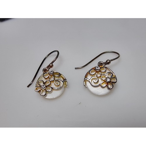 183 - A pair of pretty 925 silver drop earrings inset with mother of pearl having a floral design inset wi... 