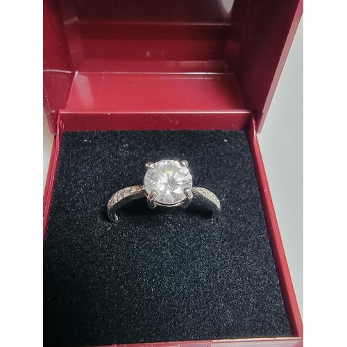 187 - A pretty 925 silver dress ring inset with a large CZ crystal stone to the centre with smaller stones... 