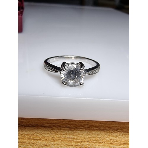 187 - A pretty 925 silver dress ring inset with a large CZ crystal stone to the centre with smaller stones... 