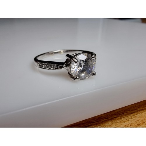 187 - A pretty 925 silver dress ring inset with a large CZ crystal stone to the centre with smaller stones... 