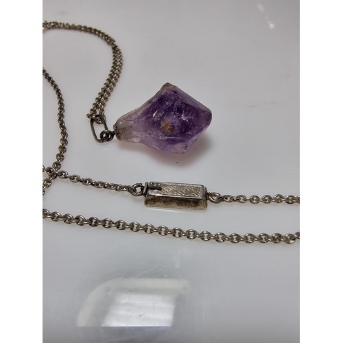 189 - A genuine amethyst rough cut pendant set on a long 23