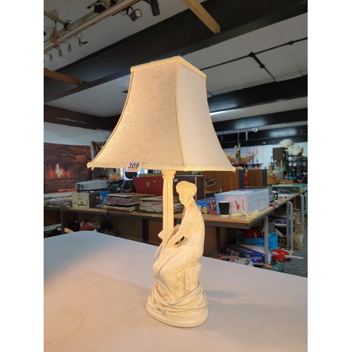 309 - Good quality plaster lamp with a sitting female figure in good order complete with shade stands at 6... 