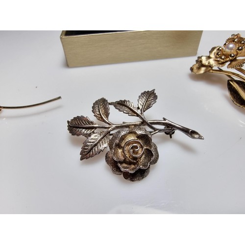 191 - A collection of 4x flower brooches to include a sterling silver rose brooch, a gold on sterling silv... 