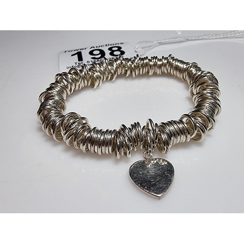 198 - A 925 silver expandable bracelet made up of many 925 silver rings, complete with a heart charm. In e... 